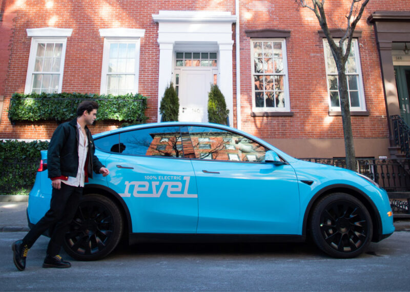 A customer hails a ride in one of Revel's powder blue Model Y EVs.