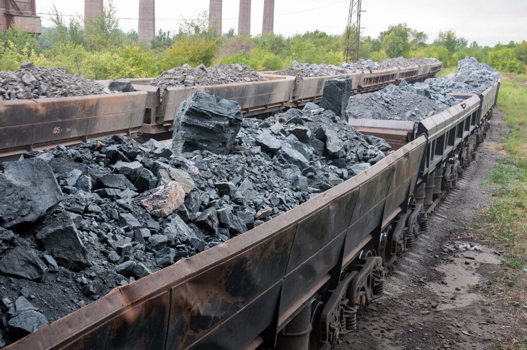 train of tipping cars loaded with raw iron ore at wagon unloading, iron ore price