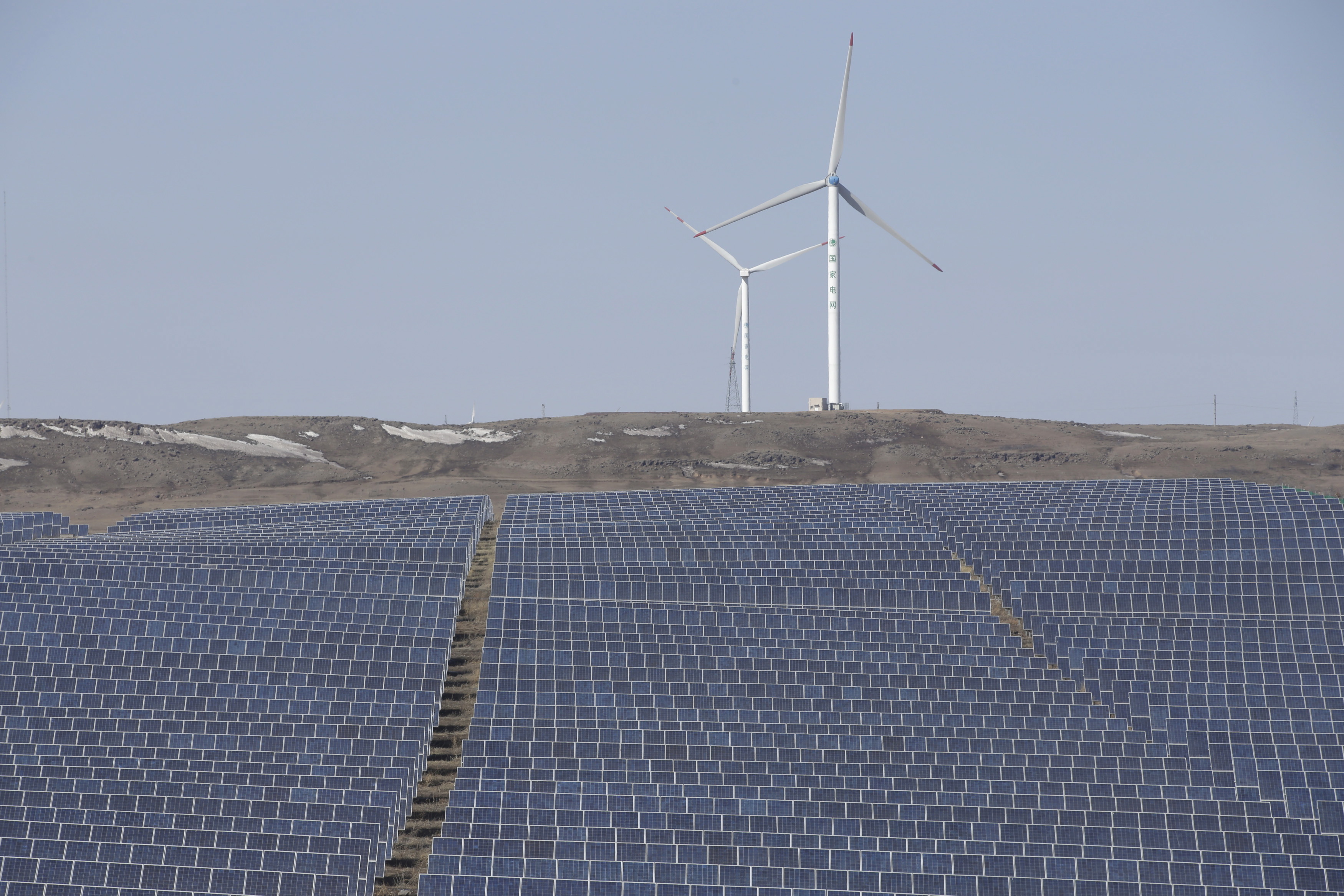 Wind turbines and solar panels are seen at a wind and solar energy storage and transmission power station from State Grid Corporation of China, in Zhangjiakou of Hebei province,